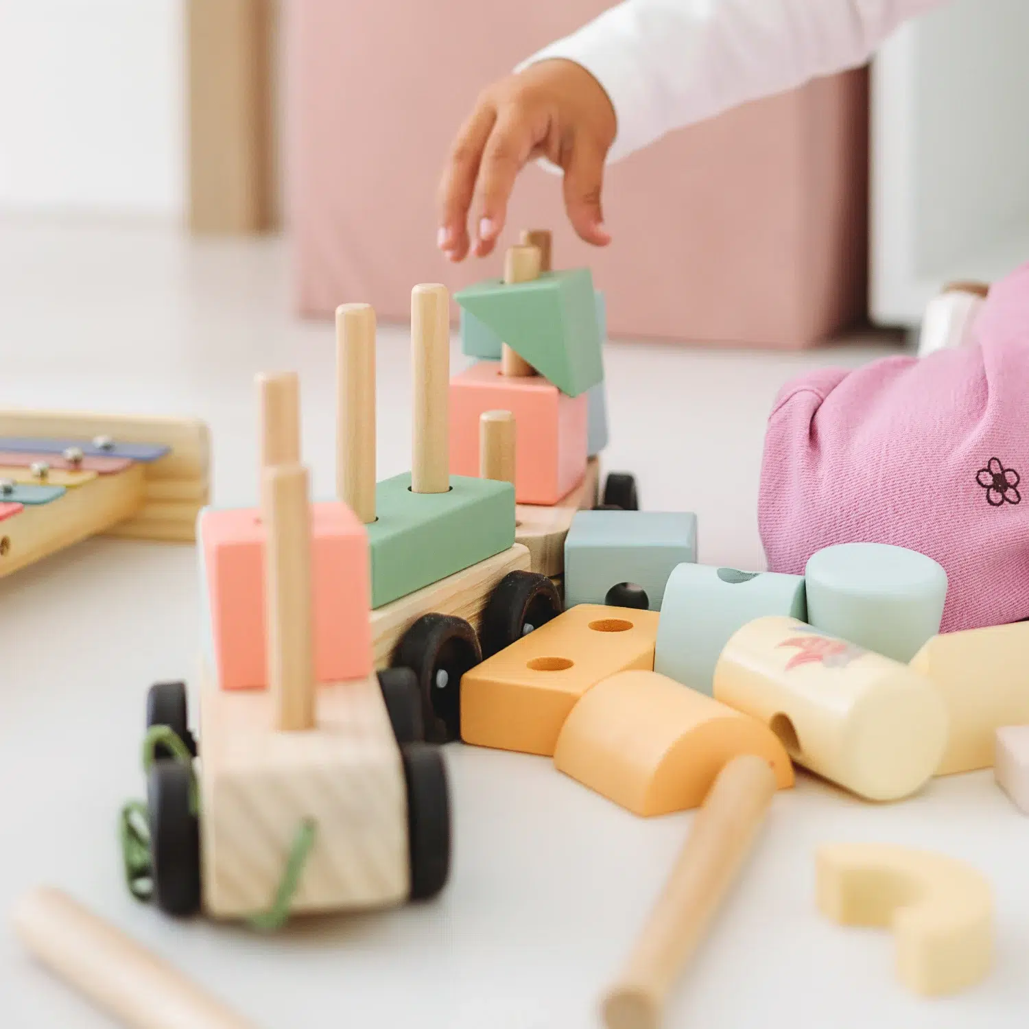 Lule drveni vozić – slaganje tokom igre Dete na podu slaže drveni vozić u pastelnim bojama