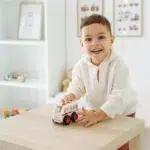Dete se igra Pino drvenom Hitnom pomoći na stolu
